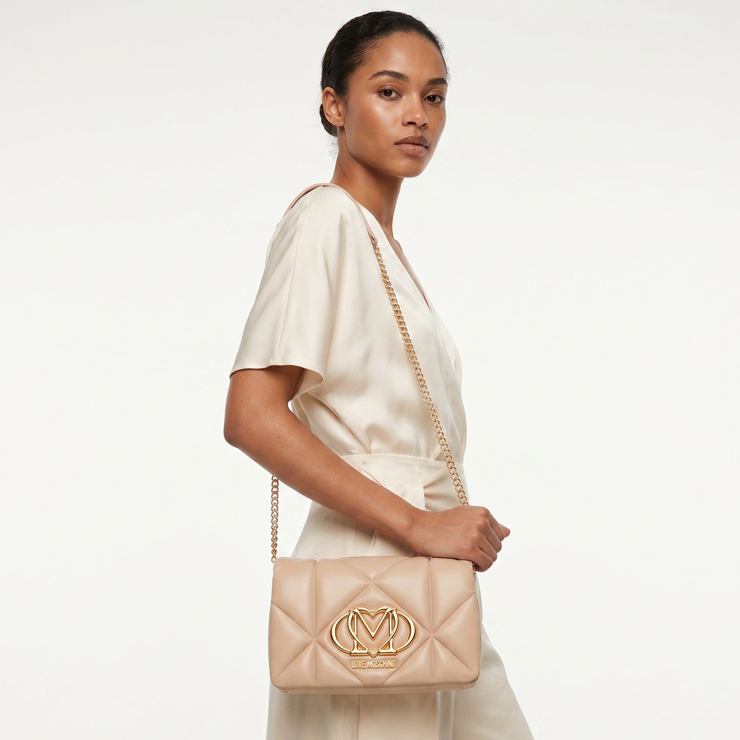Bolsa Tiracolo Love Moschino Bege Matelassê com Logo Dourado e Alça Corrente Ajustável